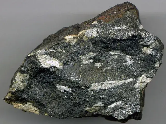 Dark cumberlandite rock with pale feldspar crystals set in black titaniferous magnetite, Rhode Island
