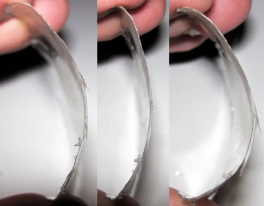 Thin cleavage sheet of muscovite mica being flexed to demonstrate its elasticity