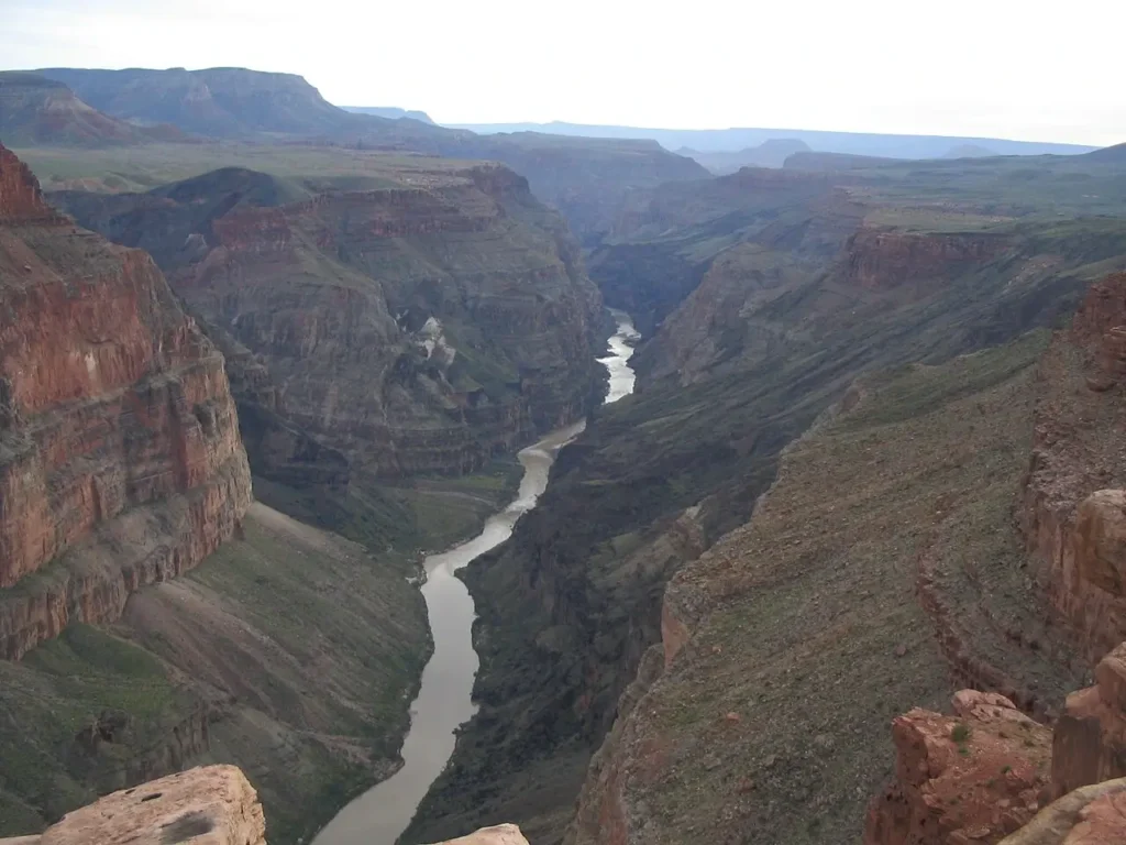 Aerial view of the Colorado River winding through the Grand Canyon, Arizona, showing layered red and orange sedimentary rock formations