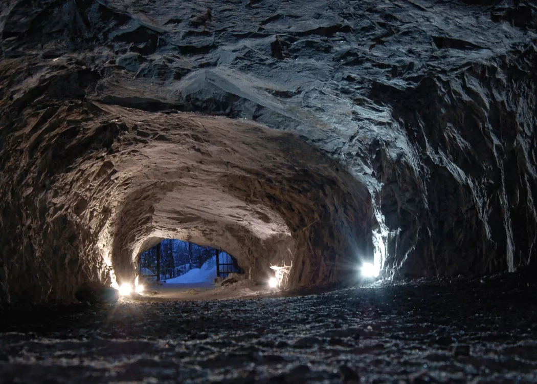 Illuminated tunnel entrance in rocky cave
