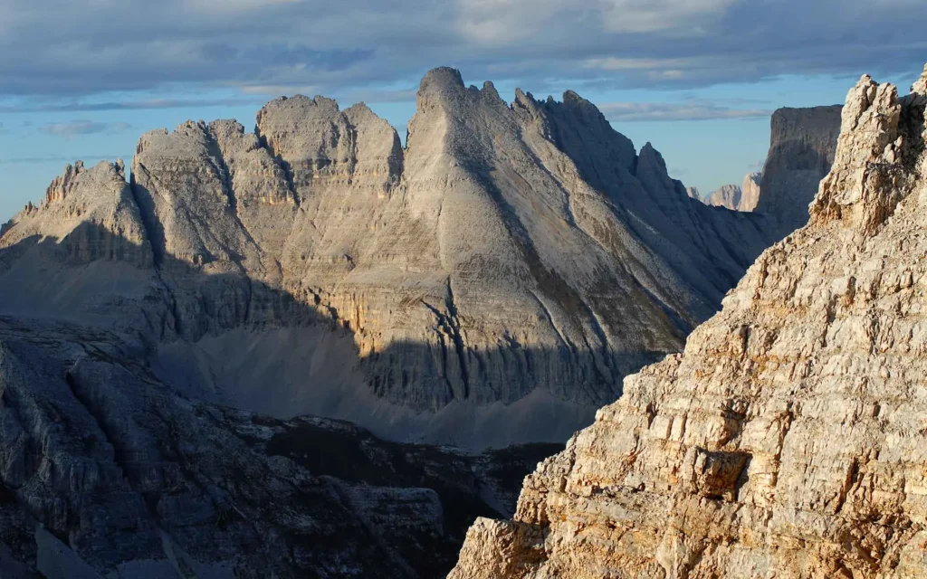 Montañas rocosas iluminadas por el sol bajo un cielo parcialmente nublado (plataforma carbonatada)