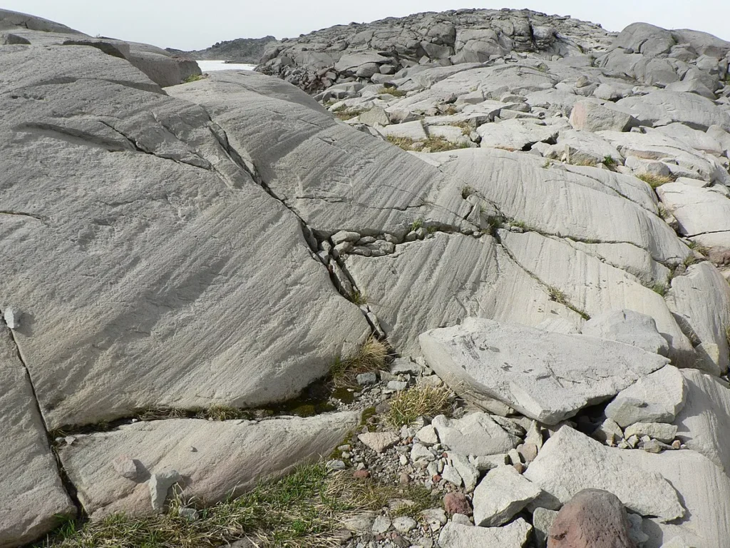 Formaciones de roca gris meteorizada con grietas y capas (estría glaciar)