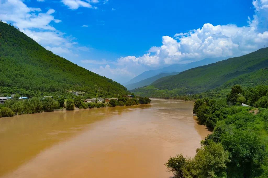 Río de aguas pardas entre montañas verdes y frondosas (río Amarillo, Huang He, en China)