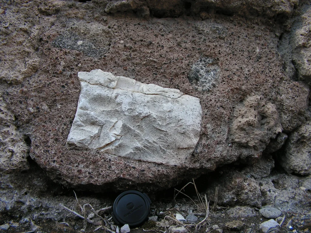 Fragmento de piedra tallada y erosionada incrustado en un muro antiguo (ejemplo de xenolito)