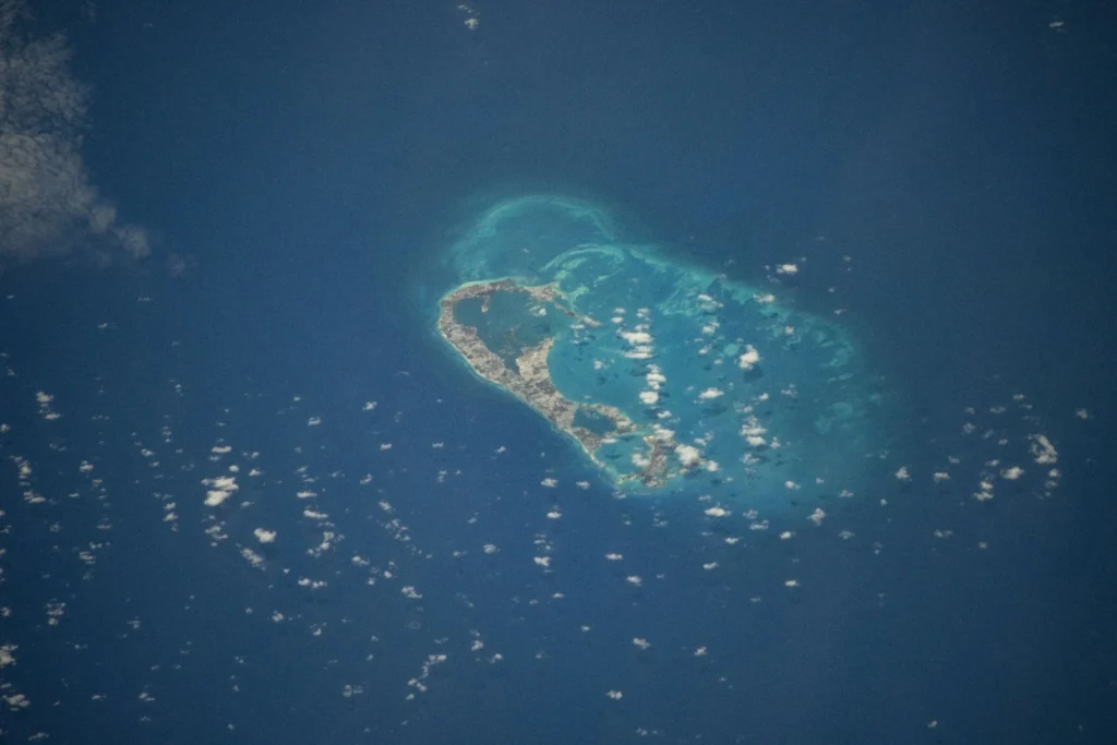 High-resolution astronaut photograph of Bermuda taken from the International Space Station in 2024, the green islands and pale reef set in deep blue ocean.