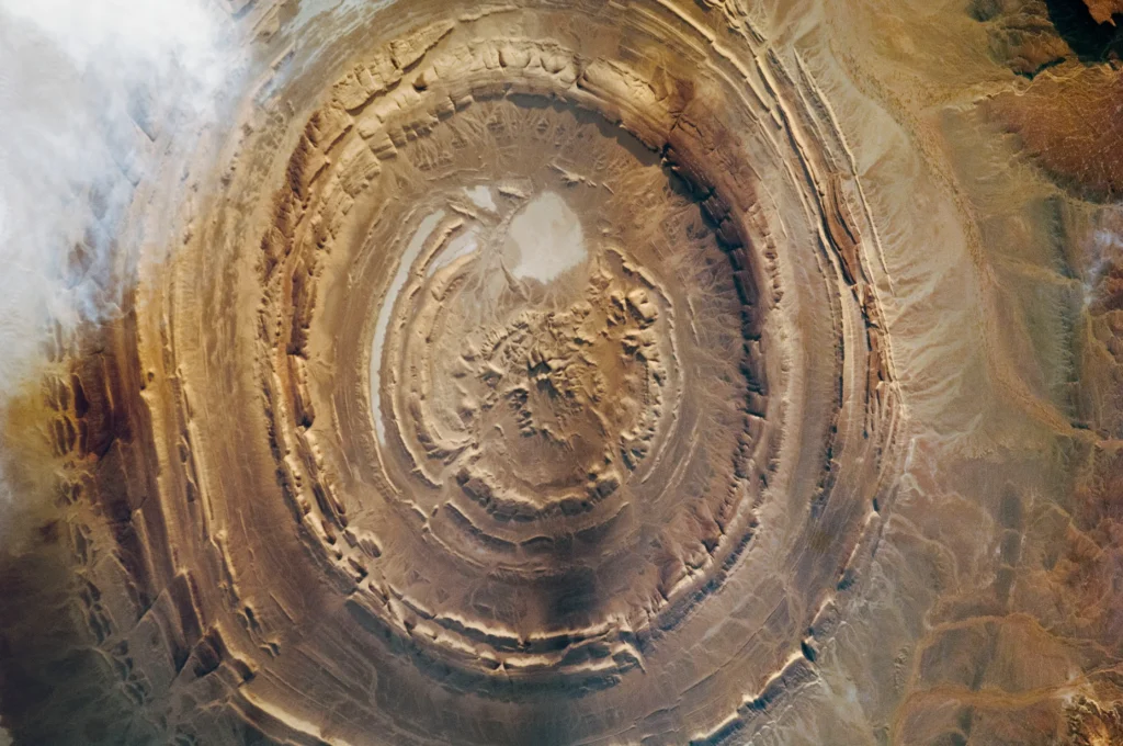 Detailed astronaut photograph of the Richat Structure from the ISS on December 17, 2011, showing concentric rock rings, faults, and surrounding desert.