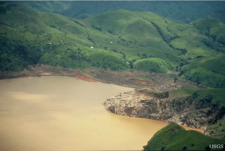 Lake Nyos, Cameroon, photographed in 1986 days after the limnic eruption, its water stained rust-brown by iron carried up from the depths