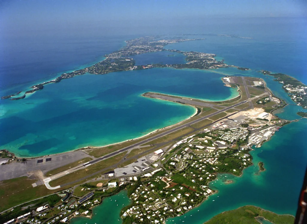 Aerial photograph of Naval Air Station Bermuda in 1993, a small flat platform of land with runways and buildings surrounded by water.