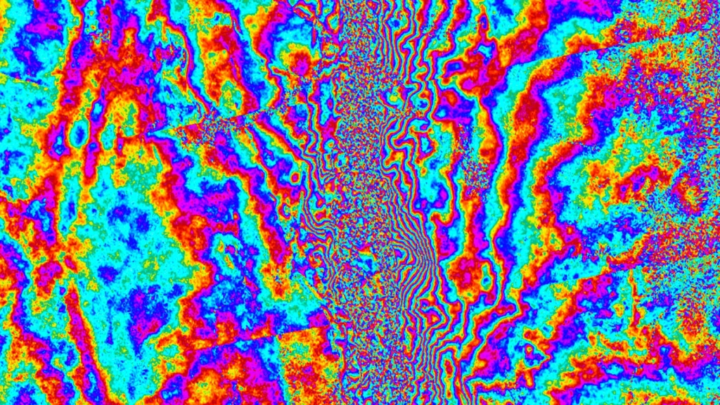 Sentinel-1 InSAR interferogram of central Myanmar after the 28 March 2025 Mw 7.7 Mandalay earthquake, showing tightly spaced concentric rainbow-coloured fringes radiating from the Sagaing Fault that quantify ground displacement on either side.
