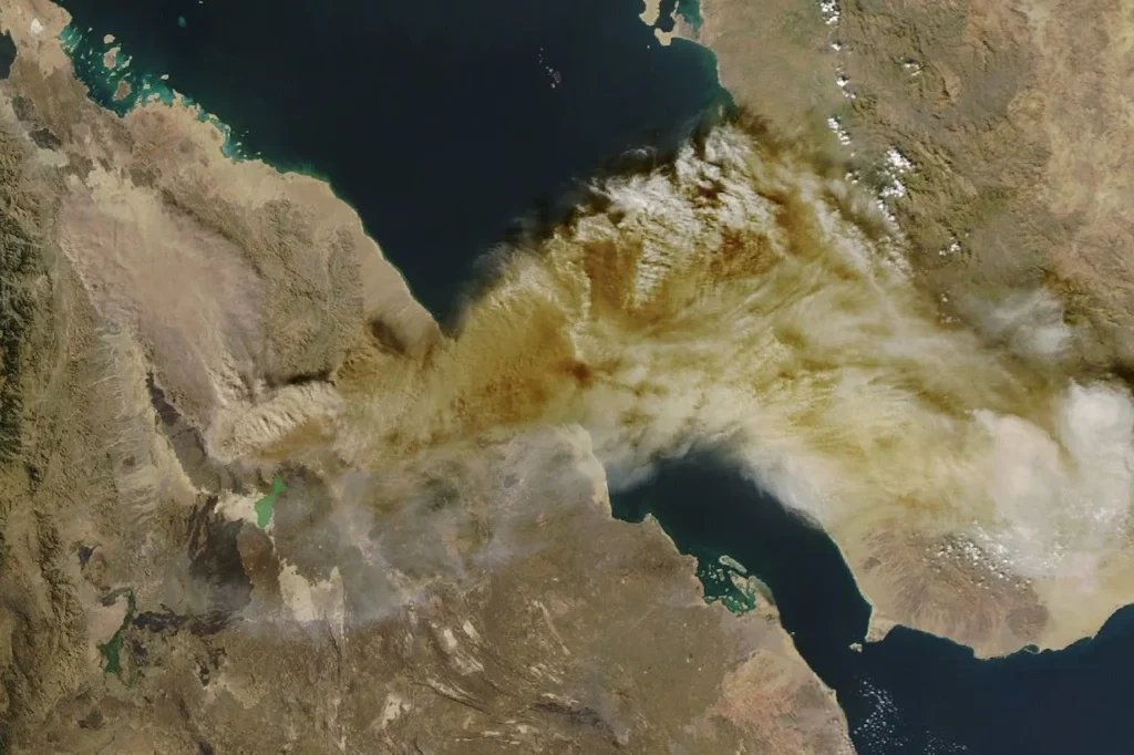 Satellite view of a large grey volcanic ash plume drifting east-northeast from northern Ethiopia across the Red Sea toward Yemen, captured by NASA's MODIS instrument on 23 November 2025