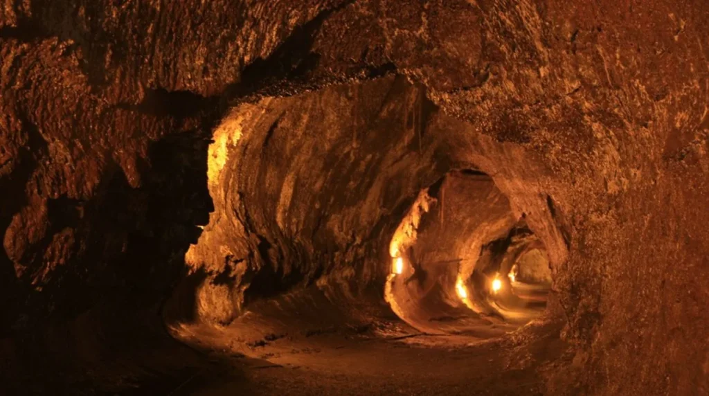The smooth-walled interior of the Nahuku (Thurston) lava tube near Kilauea, a rounded tunnel through dark basalt.