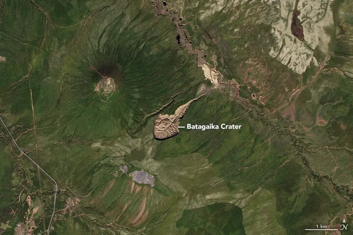 Natural-color satellite view of the Batagay megaslump in 2016, a brown tadpole-shaped scar cut into the green Siberian taiga