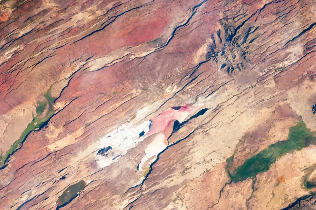 Astronaut photograph of the East African Rift Valley in Kenya showing parallel fault lines on the valley floor, the rift environment statistically linked to earthquake lights