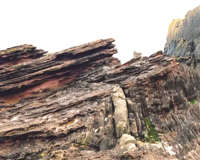 Hutton's Unconformity at Siccar Point, Scotland: gently tilted red sandstone resting on near-vertical grey greywacke beds.