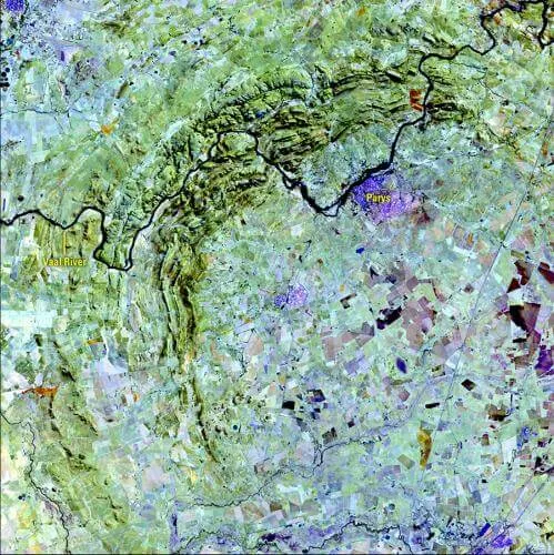 False-color Landsat 8 satellite image of the Vredefort Dome showing the crescent of concentric ridges and the Vaal River cutting across it