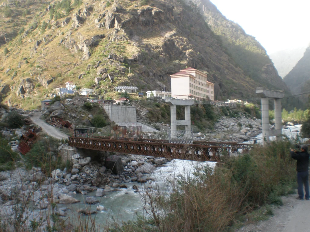 A road bridge spanning a narrow rocky gorge at the Nepal–China border crossing at Rasuwagadhi, with steep forested valley walls rising on both sides.